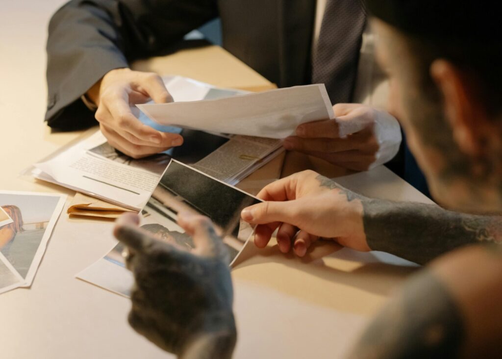 Two men discuss investigation documents in a modern office setting.